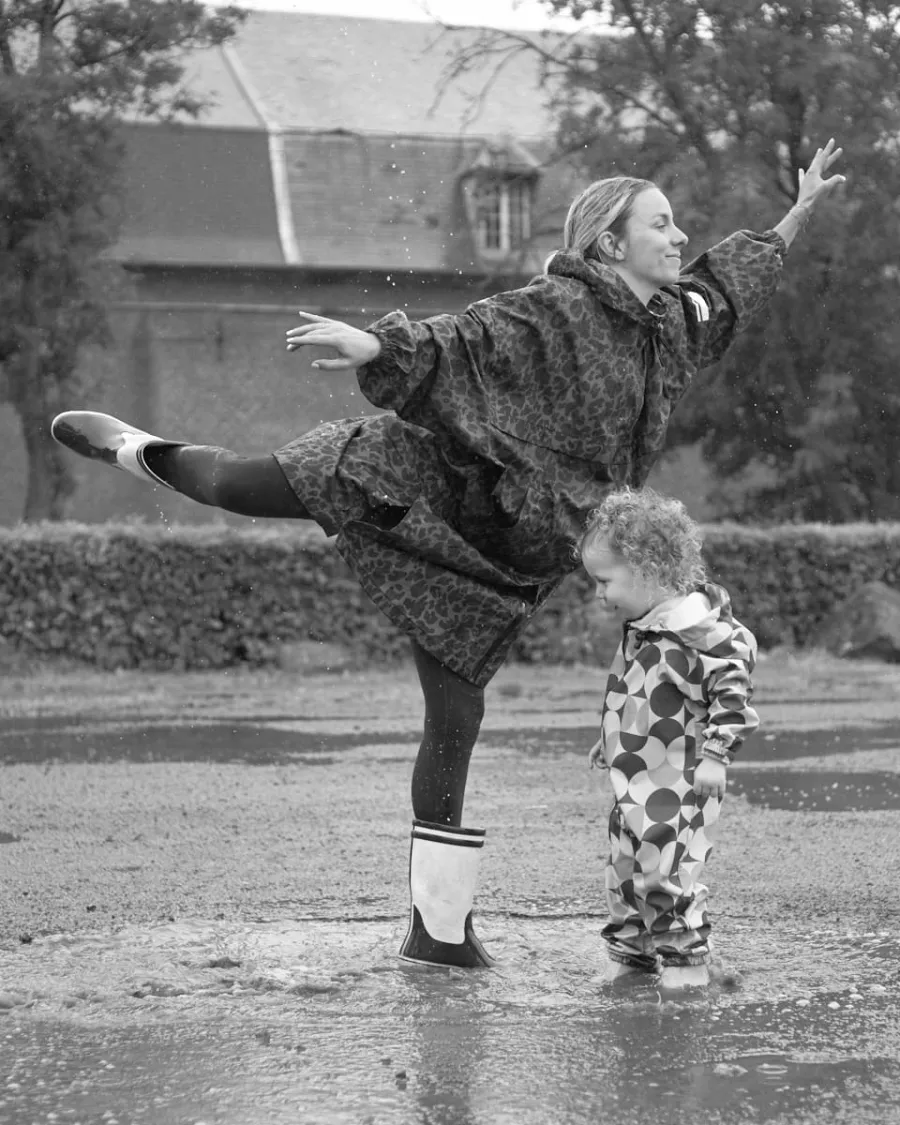 Maman et enfant dansant sous la pluie, en noir et blanc