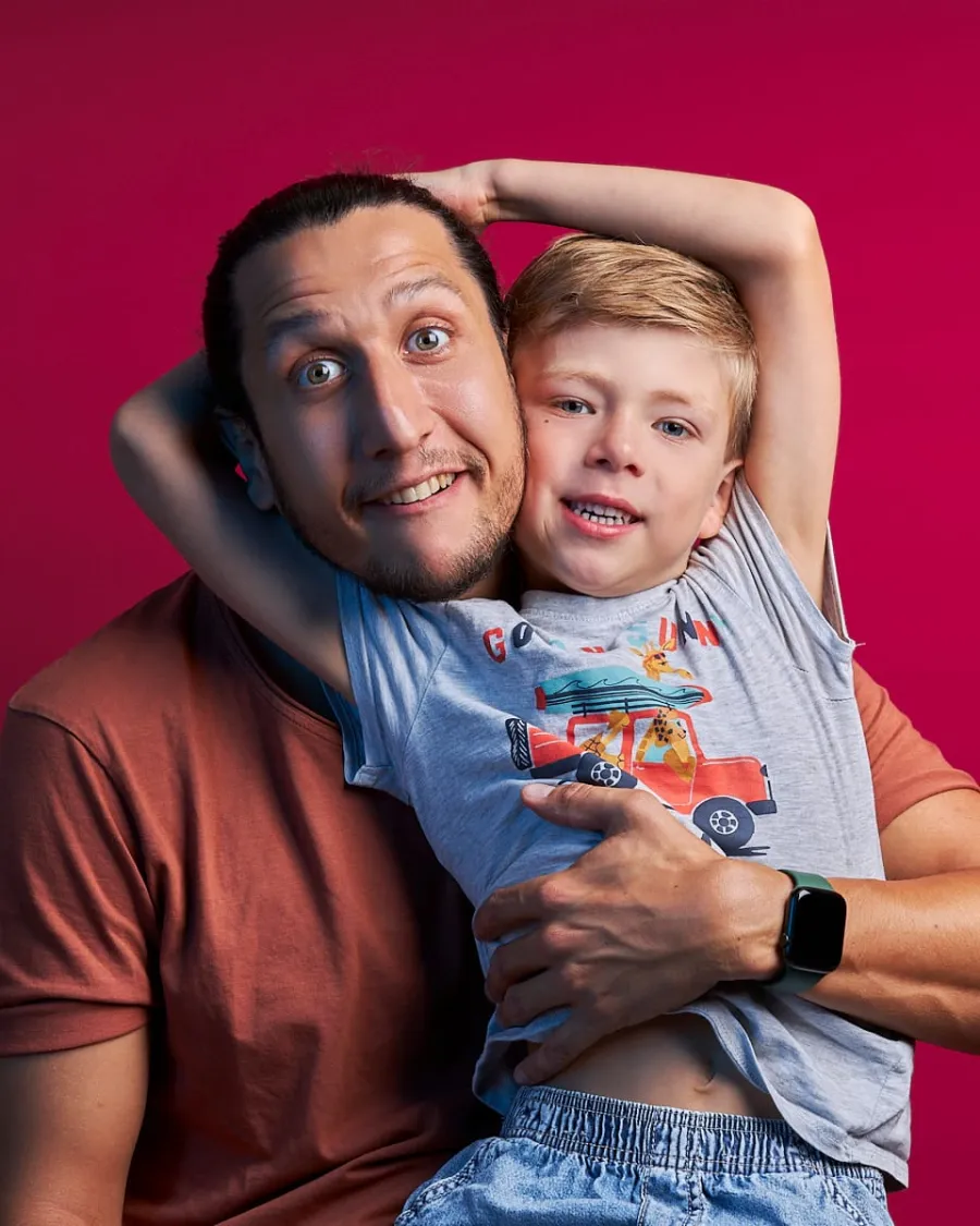 Papa et son fils faisant des grimaces sur fond rouge