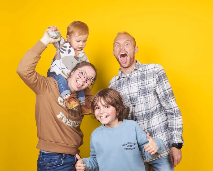 Famille joyeuse faisant les fous sur fond jaune