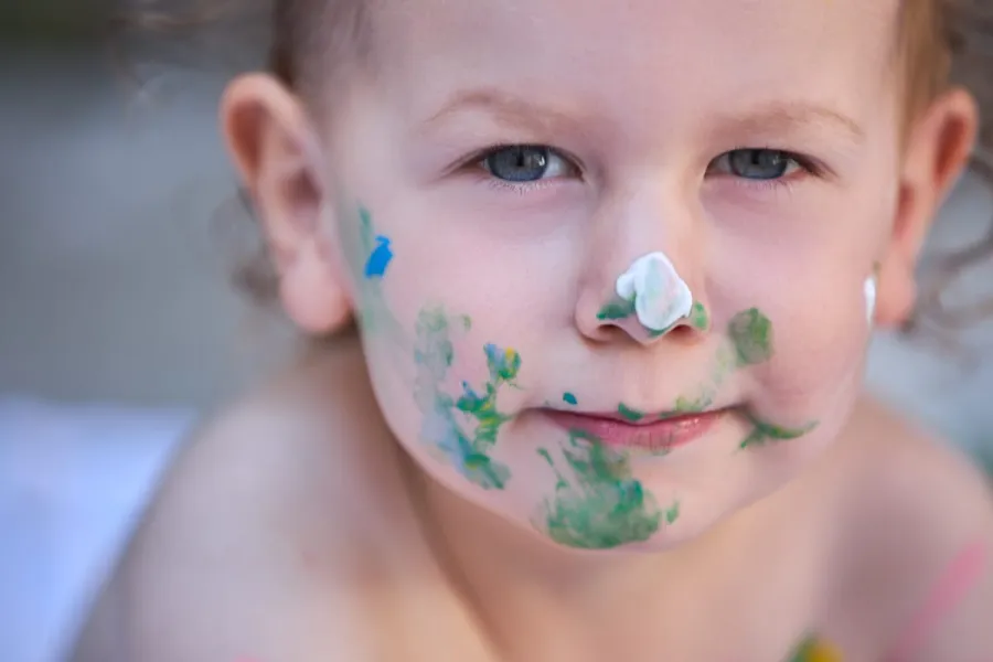 Gros plan d'un enfant au visage barbouillé de peinture